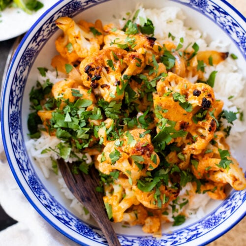 This Roasted Red Curry Cauliflower is a simple & delicious veggie dish. Cauliflower is tossed in a red curry coconut sauce & roasted. Serve with rice | ThisSavoryVegan.com #thissavoryvegan #cauliflowerrecipes #veggierecipes