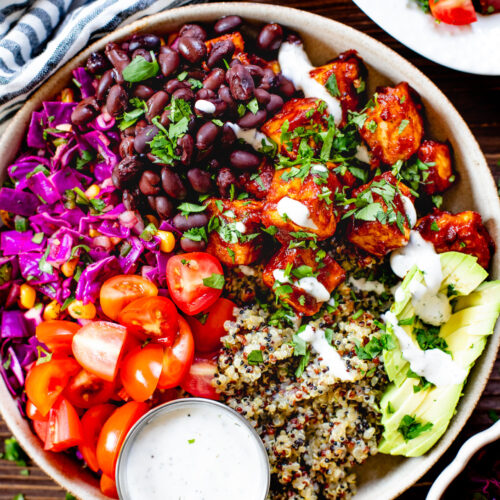 These BBQ Tofu Quinoa Bowls are layered with saucy BBQ tofu, quinoa, black beans, corn & cabbage slaw, tomatoes, avocado & vegan ranch | ThisSavoryVegan.com #thissavoryvegan #quinoabowl #easyveganrecipes