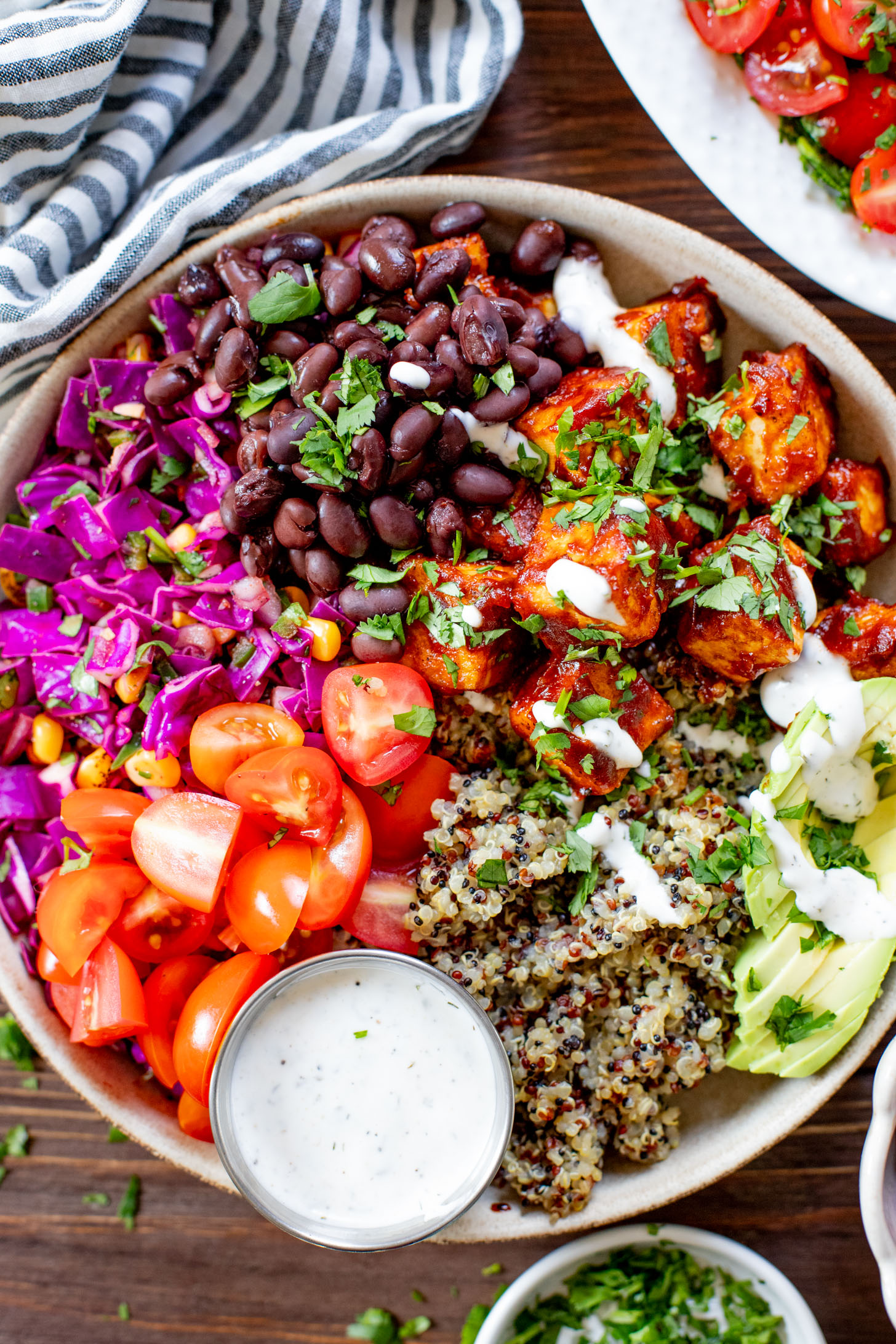 These BBQ Tofu Quinoa Bowls are layered with saucy BBQ tofu, quinoa, black beans, corn & cabbage slaw, tomatoes, avocado & vegan ranch | ThisSavoryVegan.com #thissavoryvegan #quinoabowl #easyveganrecipes