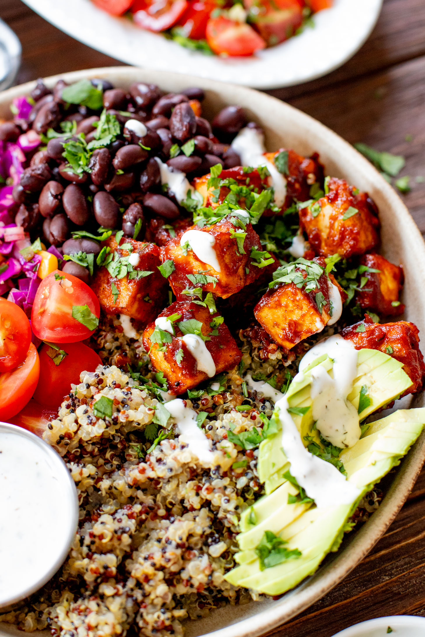 These BBQ Tofu Quinoa Bowls are layered with saucy BBQ tofu, quinoa, black beans, corn & cabbage slaw, tomatoes, avocado & vegan ranch | ThisSavoryVegan.com #thissavoryvegan #quinoabowl #easyveganrecipes