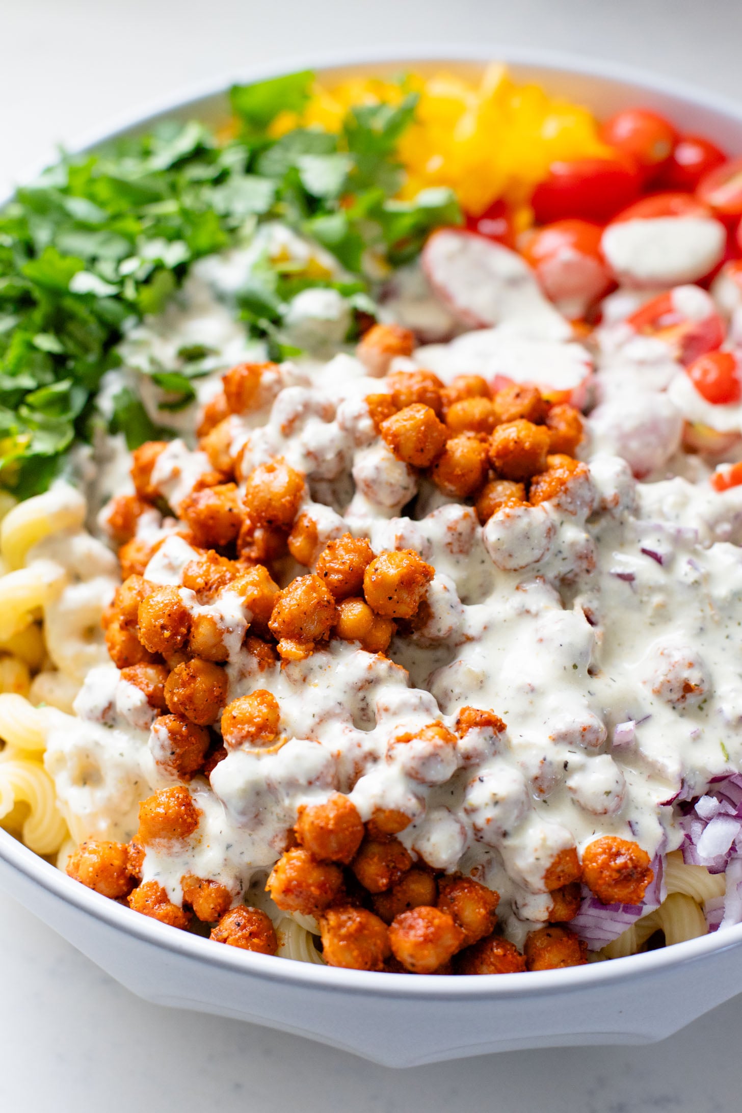 This Buffalo Chickpea Pasta Salad is the ultimate vegan salad! Made with crispy buffalo chickpeas, dairy-free green chile ranch, pasta & veggies | ThisSavoryVegan.com