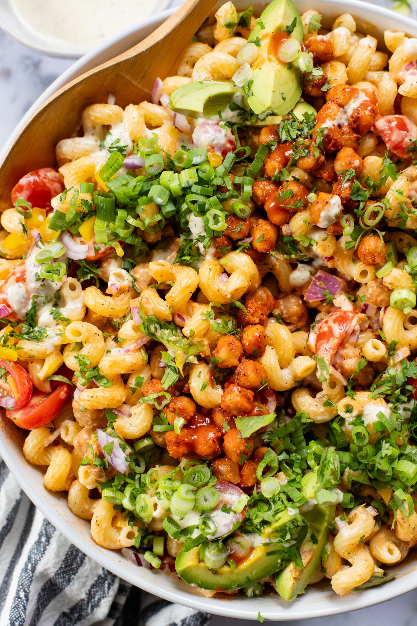 This Buffalo Chickpea Pasta Salad is the ultimate vegan salad! Made with crispy buffalo chickpeas, dairy-free green chile ranch, pasta & veggies | ThisSavoryVegan.com