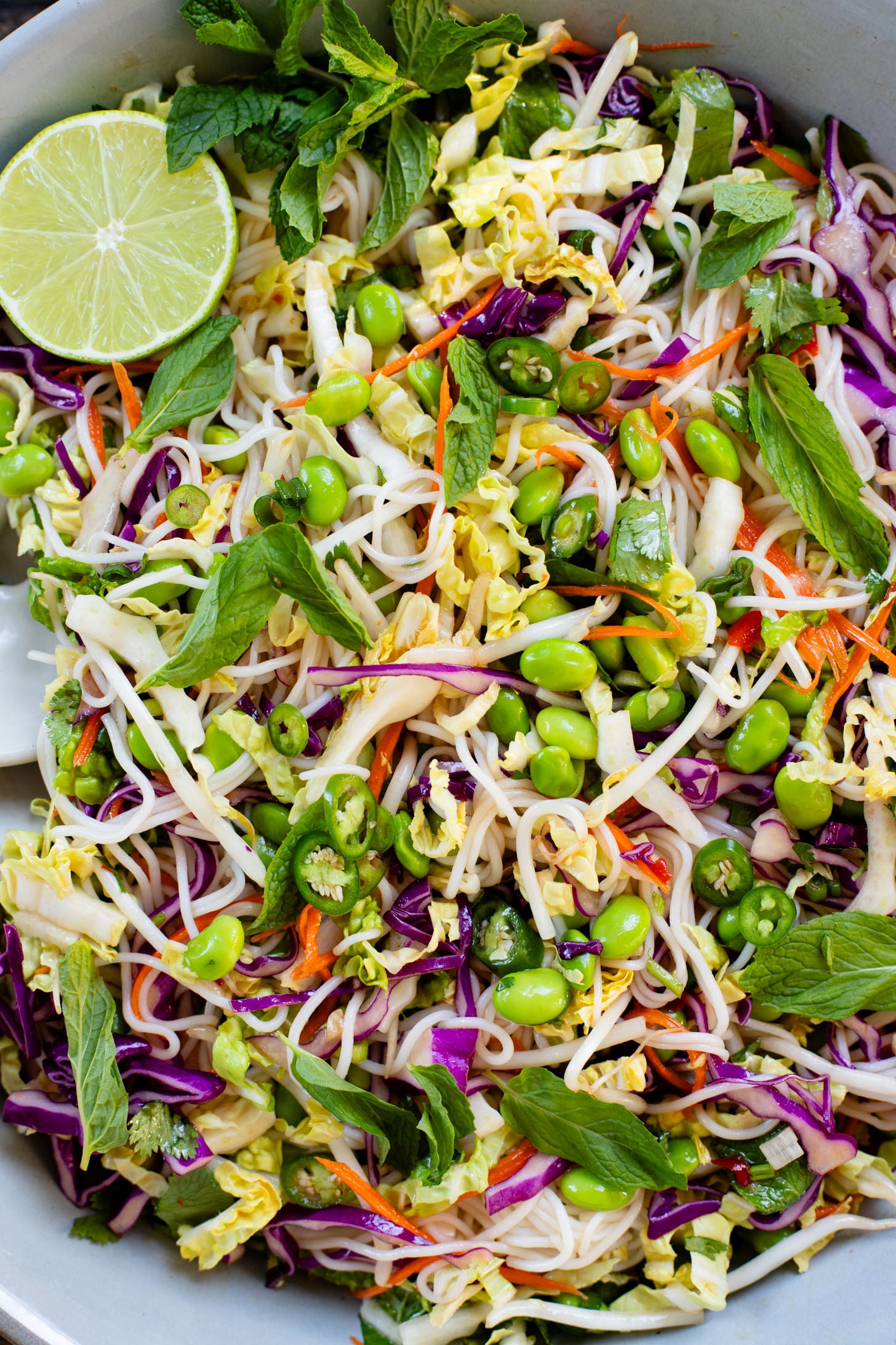 This Edamame Rice Noodle Salad is veggie (and protein) packed. Made with rice noodles and served with a sweet chili lime dressing | ThisSavoryVegan.com