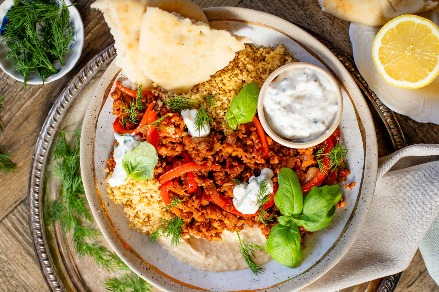 These Vegan Harissa Beef Couscous Bowls are layered with lemon couscous, hummus, veggies, "beef" crumbles and vegan feta sauce | ThisSavoryVegan.com