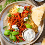 These Vegan Harissa Beef Couscous Bowls are layered with lemon couscous, hummus, veggies, "beef" crumbles and vegan feta sauce | ThisSavoryVegan.com