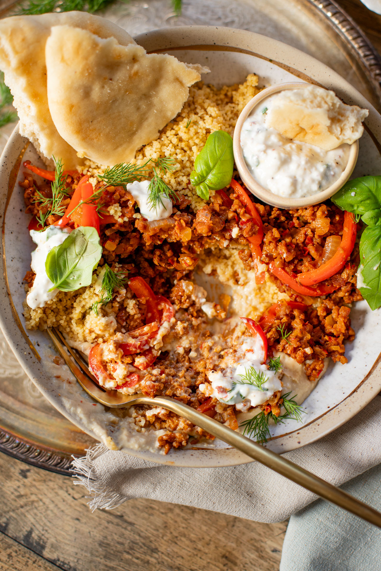 These Vegan Harissa Beef Couscous Bowls are layered with lemon couscous, hummus, veggies, "beef" crumbles and vegan feta sauce | ThisSavoryVegan.com