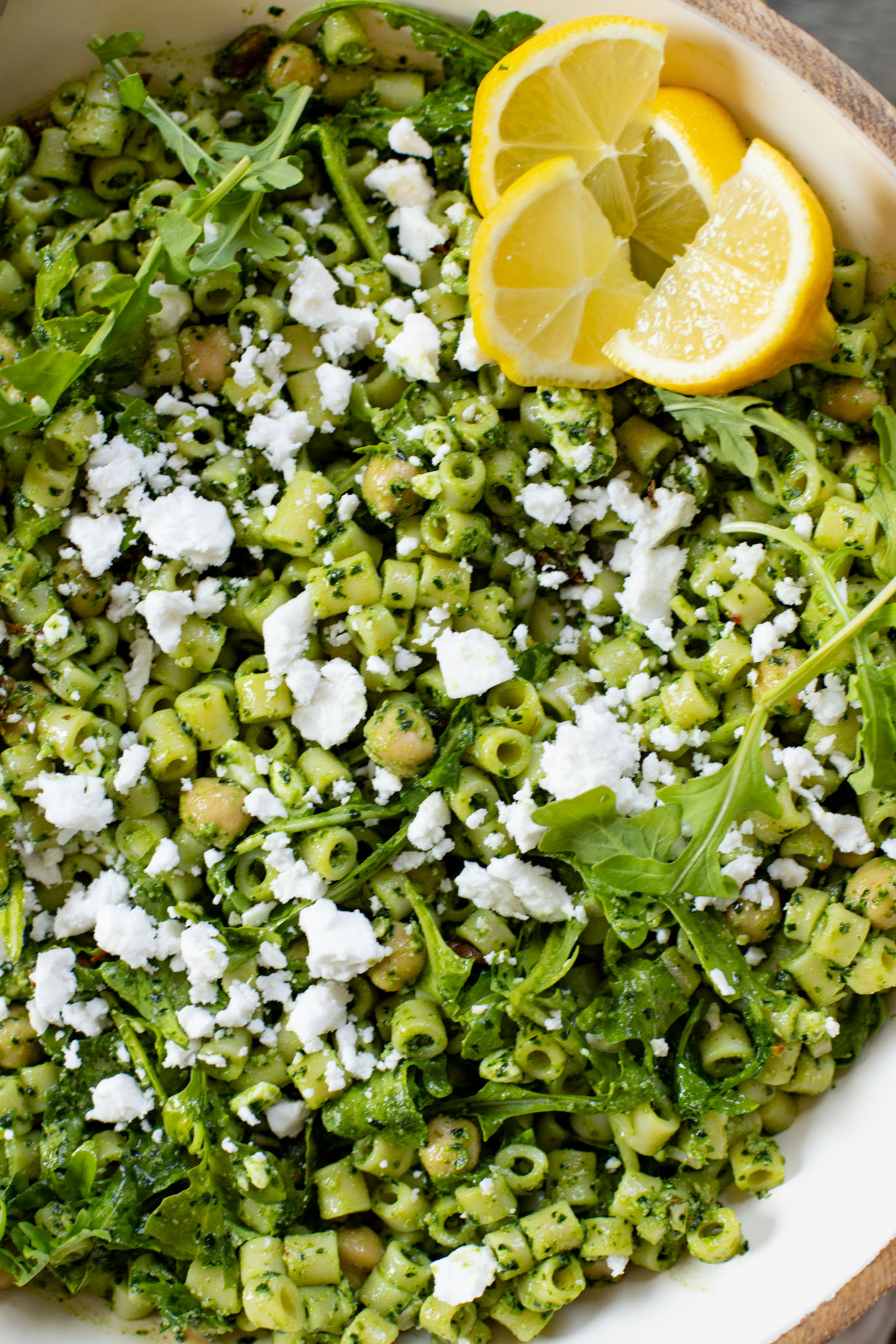 This Kale Pesto Pasta Salad is made with a dairy-free, earthy kale & basil pesto, vegan feta, chickpeas, sun-dried tomatoes & arugula | ThisSavoryVegan.com