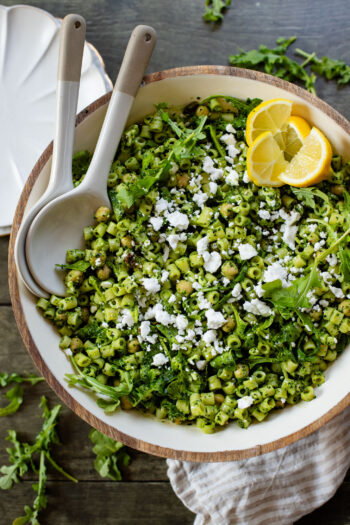 This Kale Pesto Pasta Salad is made with a dairy-free, earthy kale & basil pesto, vegan feta, chickpeas, sun-dried tomatoes & arugula | ThisSavoryVegan.com