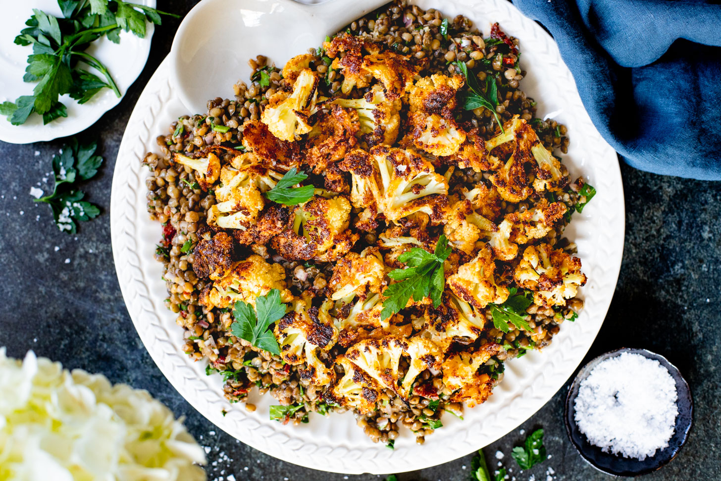 This Parmesan Cauliflower & Lentil Salad is 100% vegan. The cauliflower is coated in vegan parmesan & roasted until crispy. Served over a fresh lentil salad | ThisSavoryVegan.com