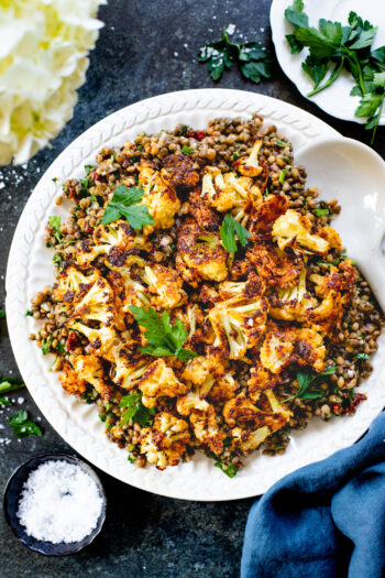 This Parmesan Cauliflower & Lentil Salad is 100% vegan. The cauliflower is coated in vegan parmesan & roasted until crispy. Served over a fresh lentil salad | ThisSavoryVegan.com