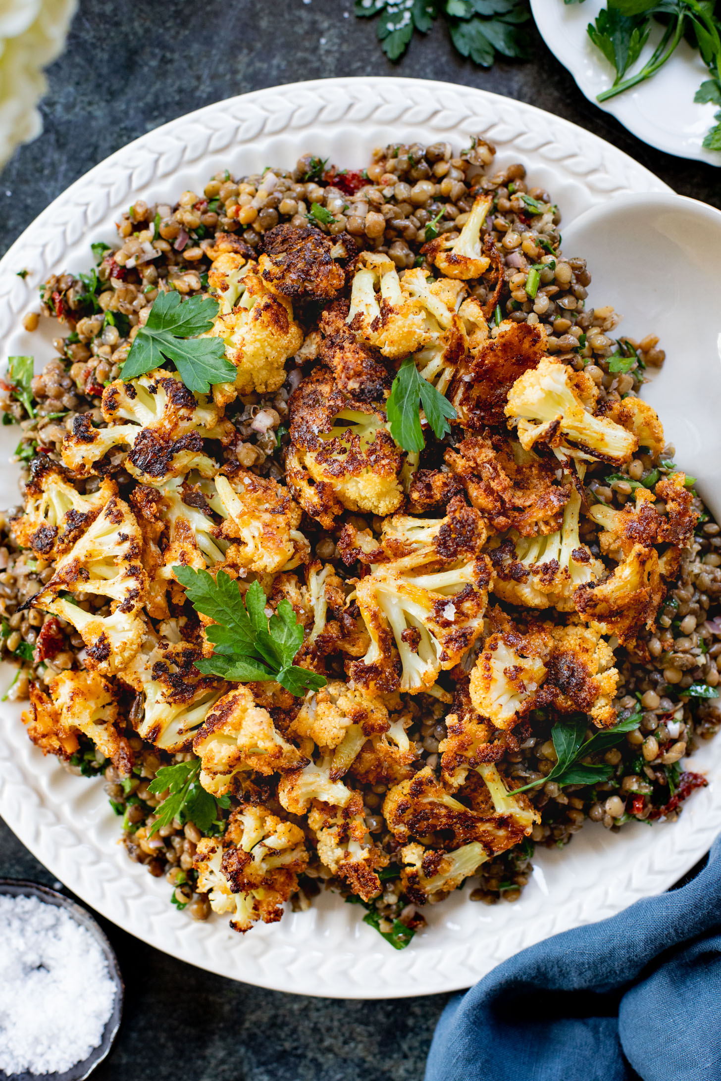 This Parmesan Cauliflower & Lentil Salad is 100% vegan. The cauliflower is coated in vegan parmesan & roasted until crispy. Served over a fresh lentil salad | ThisSavoryVegan.com