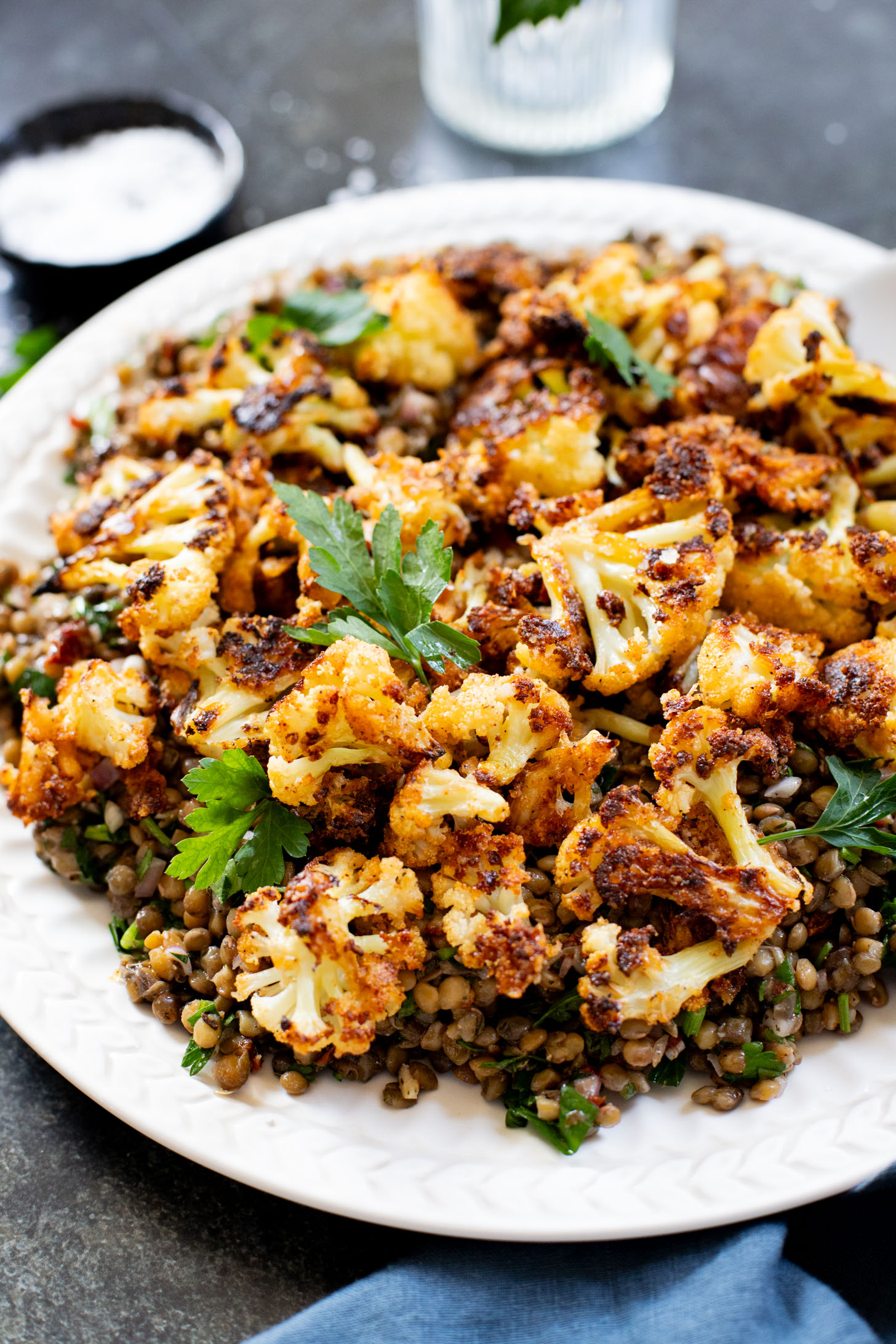 This Parmesan Cauliflower & Lentil Salad is 100% vegan. The cauliflower is coated in vegan parmesan & roasted until crispy. Served over a fresh lentil salad | ThisSavoryVegan.com
