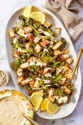This Roasted Broccoli Salad is layered with crispy shallots & broccoli, garlic croutons, sunflower seeds and lemon tahini dressing | ThisSavoryVegan.com