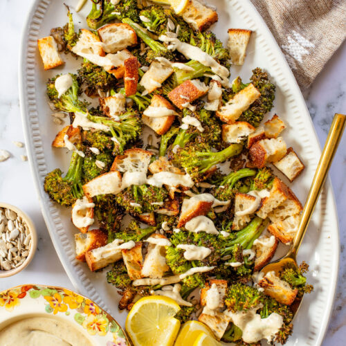 This Roasted Broccoli Salad is layered with crispy shallots & broccoli, garlic croutons, sunflower seeds and lemon tahini dressing | ThisSavoryVegan.com