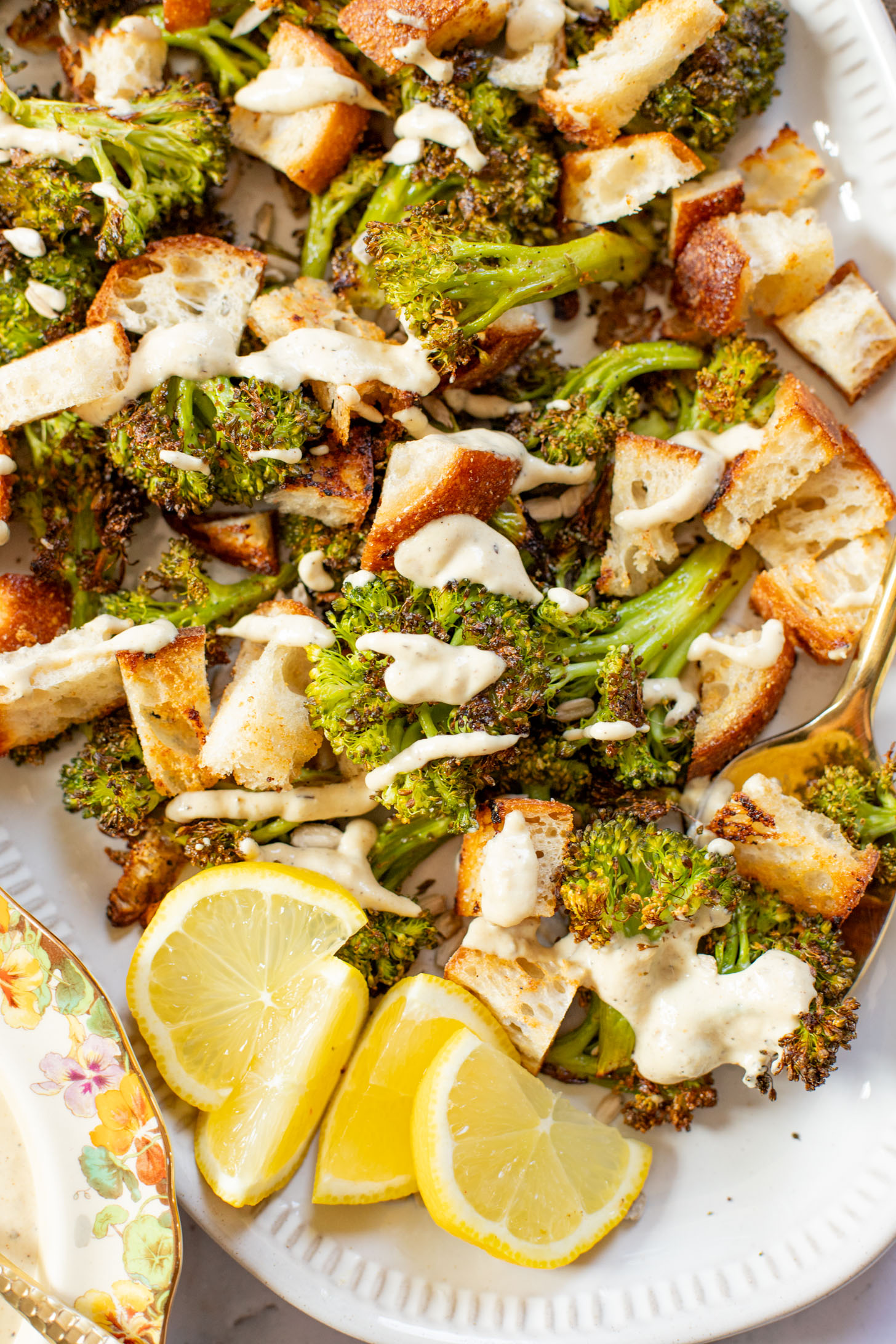 This Roasted Broccoli Salad is layered with crispy shallots & broccoli, garlic croutons, sunflower seeds and lemon tahini dressing | ThisSavoryVegan.com