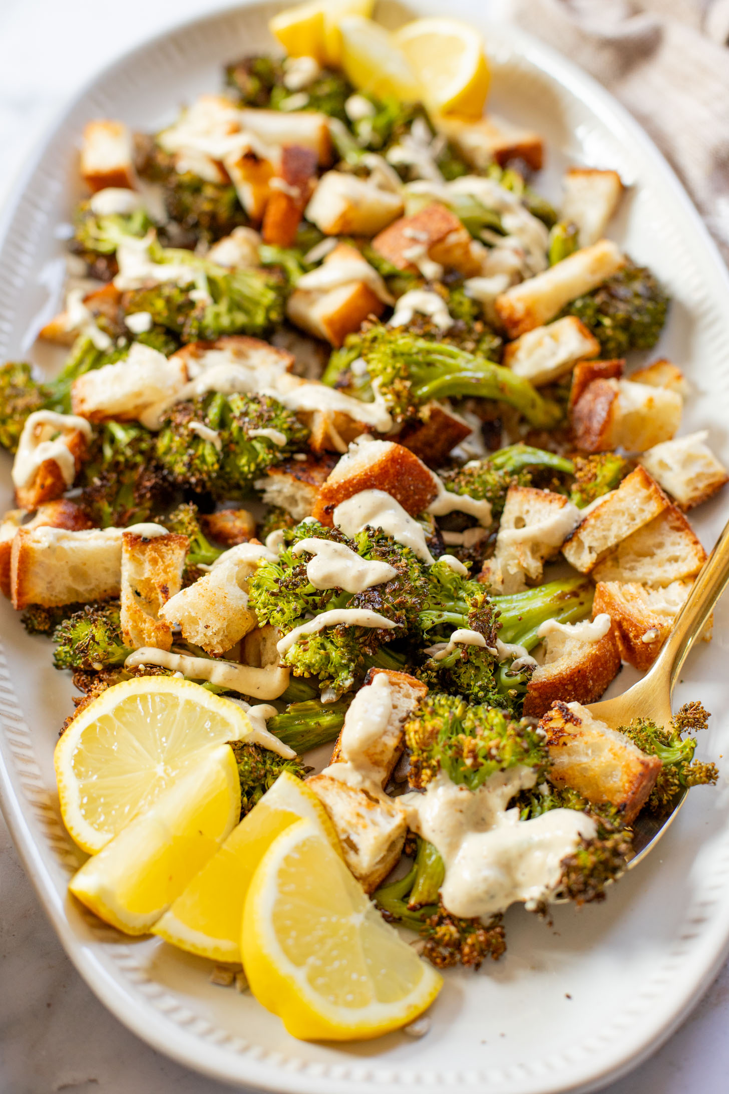 This Roasted Broccoli Salad is layered with crispy shallots & broccoli, garlic croutons, sunflower seeds and lemon tahini dressing | ThisSavoryVegan.com