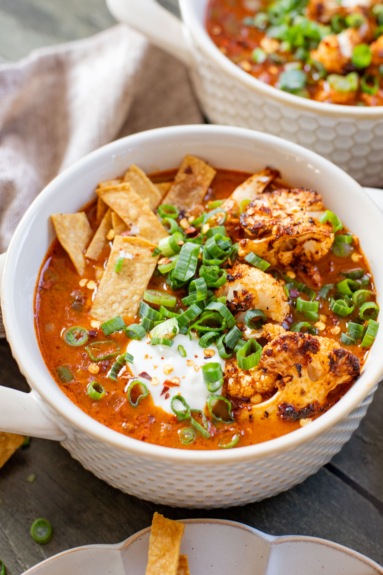 This Roasted Cauliflower Tortilla Soup is cozy and veggie packed! The perfect bowl of soup to warm up with on a cold day | ThisSavoryVegan.com