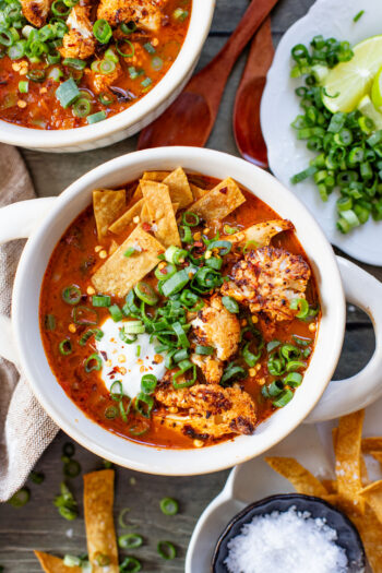 This Roasted Cauliflower Tortilla Soup is cozy and veggie packed! The perfect bowl of soup to warm up with on a cold day | ThisSavoryVegan.com