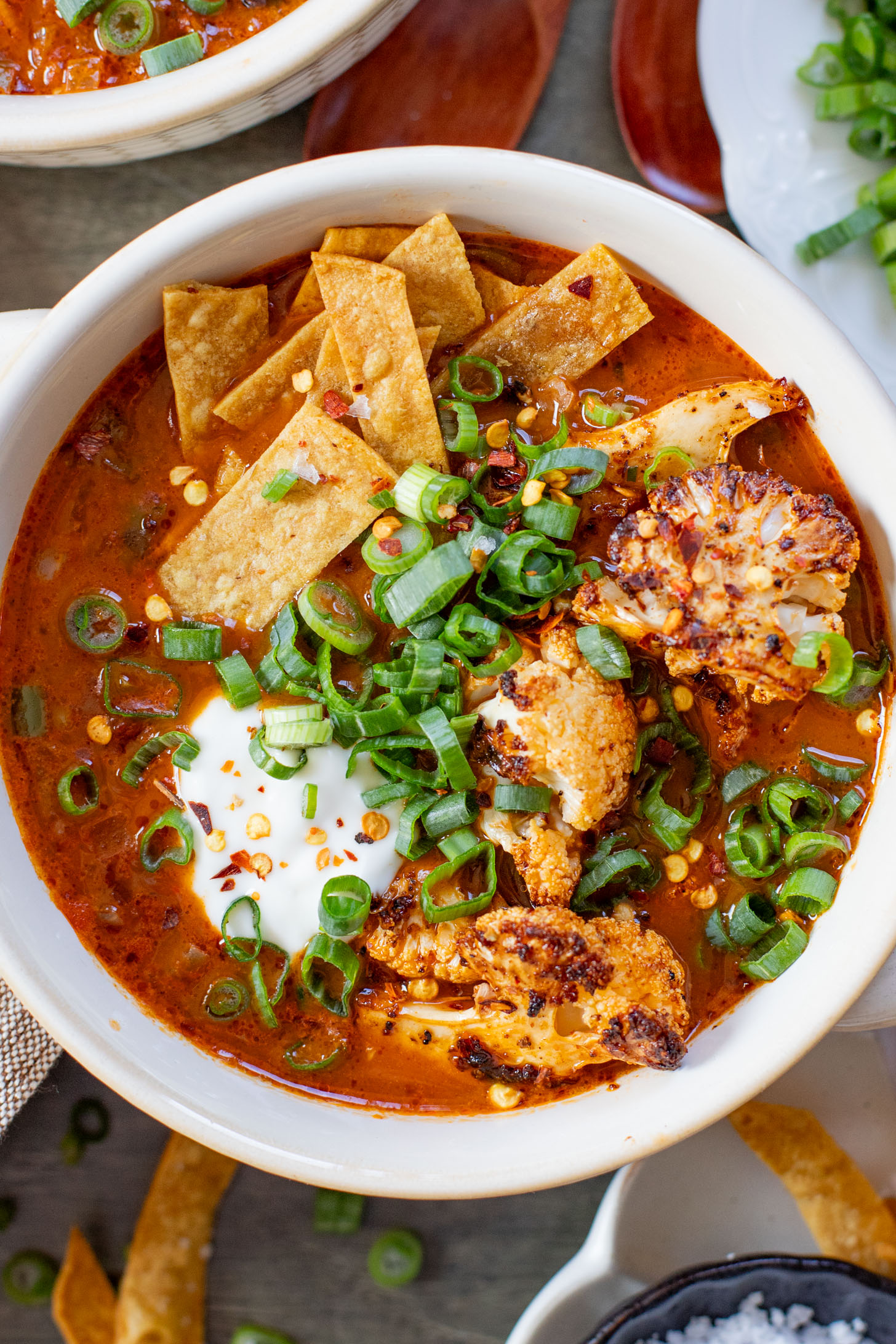 This Roasted Cauliflower Tortilla Soup is cozy and veggie packed! The perfect bowl of soup to warm up with on a cold day | ThisSavoryVegan.com