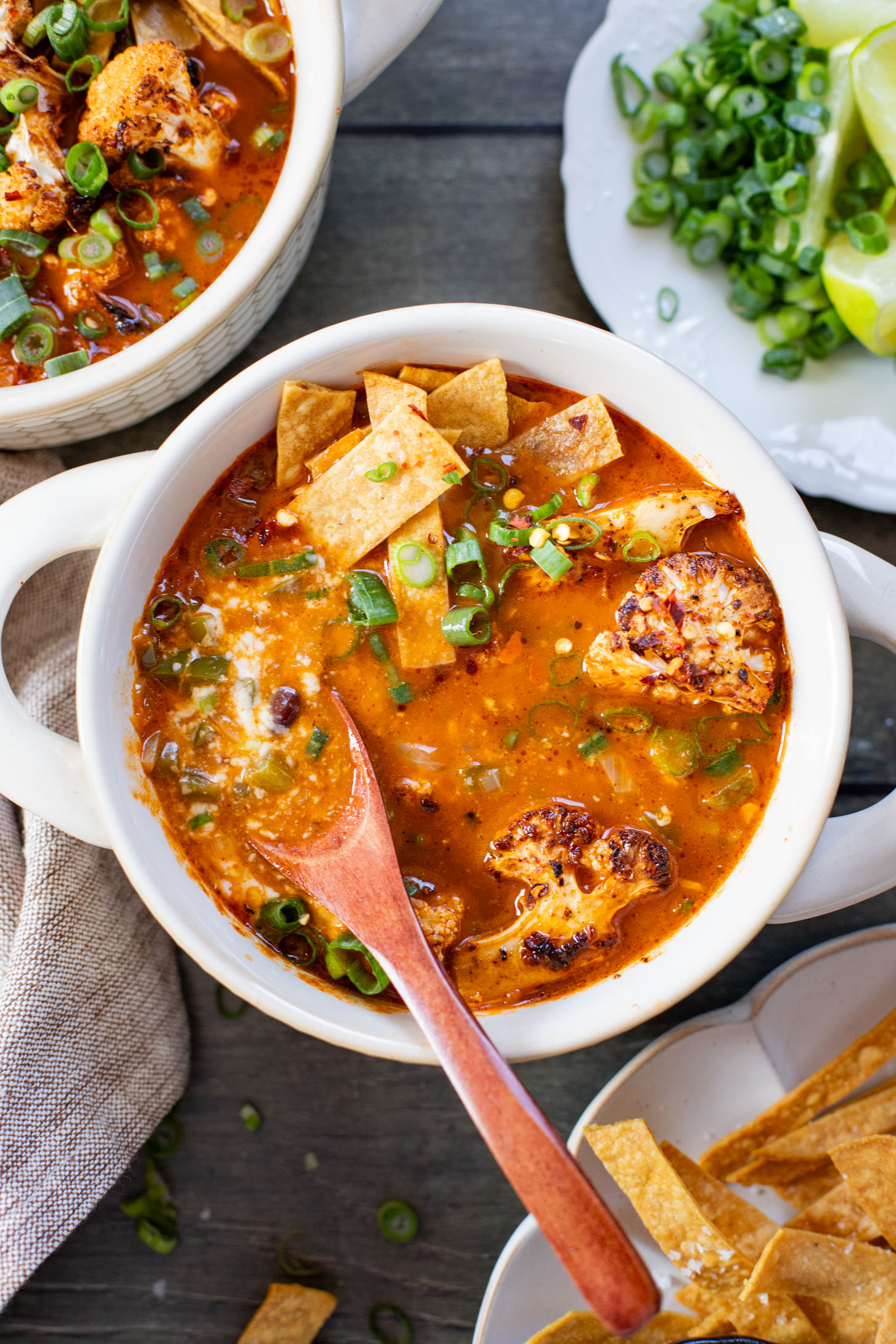 This Roasted Cauliflower Tortilla Soup is cozy and veggie packed! The perfect bowl of soup to warm up with on a cold day | ThisSavoryVegan.com