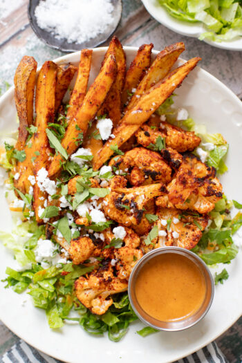 These Roasted Cauliflower & Potato Bowls are layered with seasoned roasted veggies, fresh romaine & a chipotle agave vinaigrette | ThisSavoryVegan.com