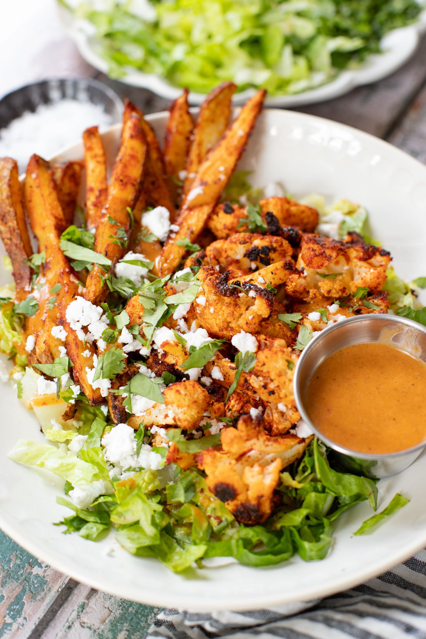 These Roasted Cauliflower & Potato Bowls are layered with seasoned roasted veggies, fresh romaine & a chipotle agave vinaigrette | ThisSavoryVegan.com
