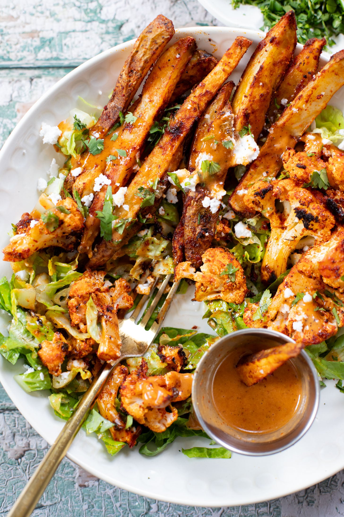These Roasted Cauliflower & Potato Bowls are layered with seasoned roasted veggies, fresh romaine & a chipotle agave vinaigrette | ThisSavoryVegan.com