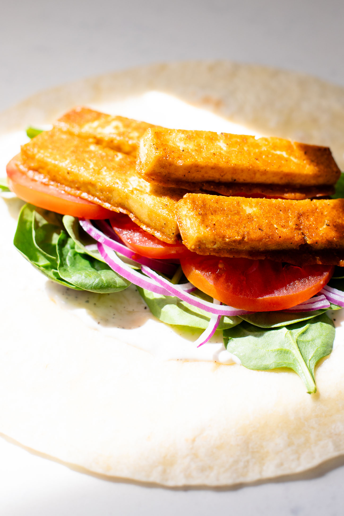 These Cajun Tofu Wraps are filled with baked cajun tofu, veggies and a dairy-free lemon pepper aioli. A great lunch or quick dinner | ThisSavoryVegan.com