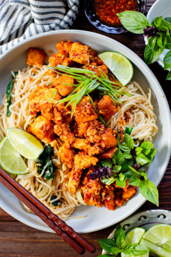 This Chili Crunch Tofu & Spinach Rice Noodles recipe is a better than takeout vegan dinner! Crispy tofu, veggie rice noodles & fresh herbs | ThisSavoryVegan.com