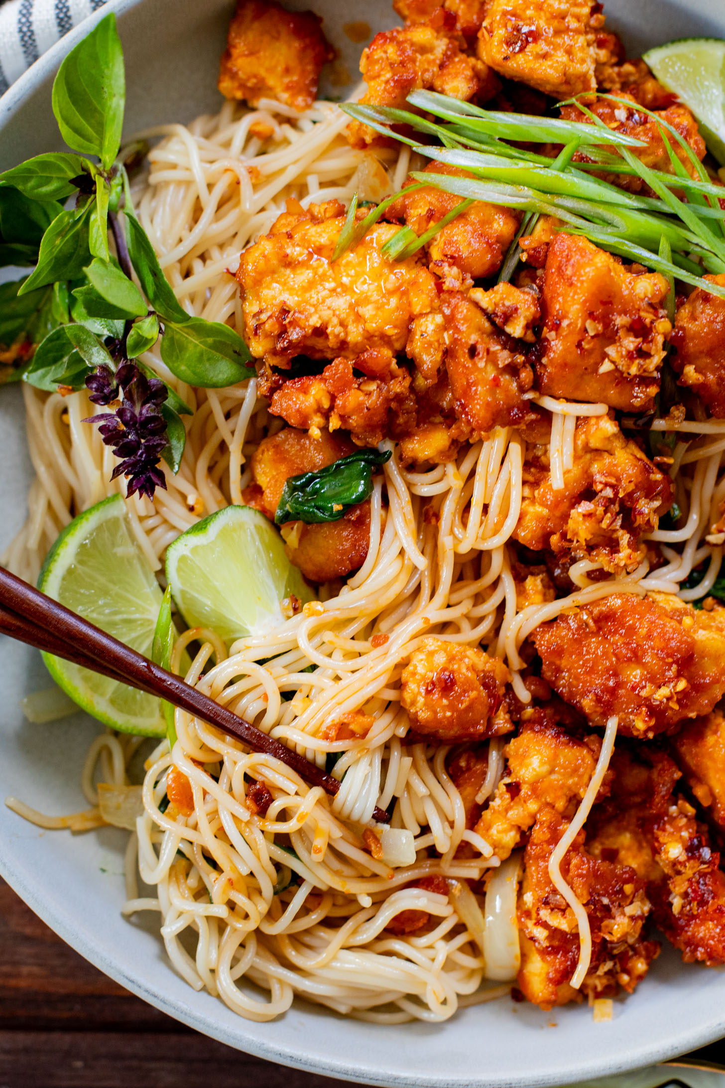 This Chili Crunch Tofu & Spinach Rice Noodles recipe is a better than takeout vegan dinner! Crispy tofu, veggie rice noodles & fresh herbs | ThisSavoryVegan.com