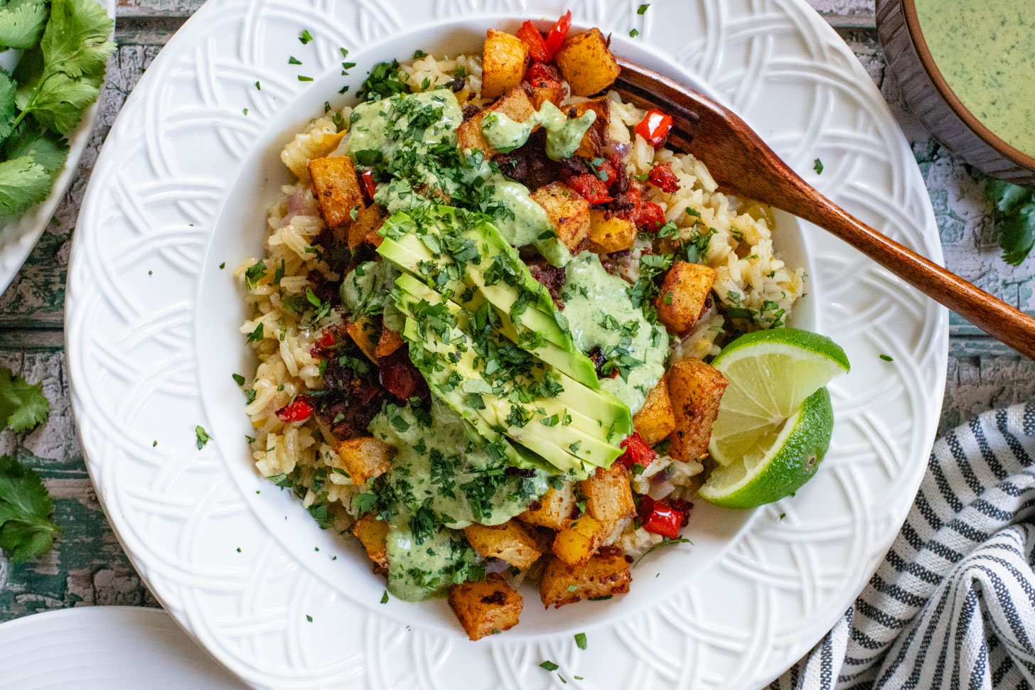 These Crispy Potato & Green Chile Rice Bowls are filled with flavor-packed rice, crispy potatoes, soy chorizo & a cilantro lime sauce | ThisSavoryVegan.com