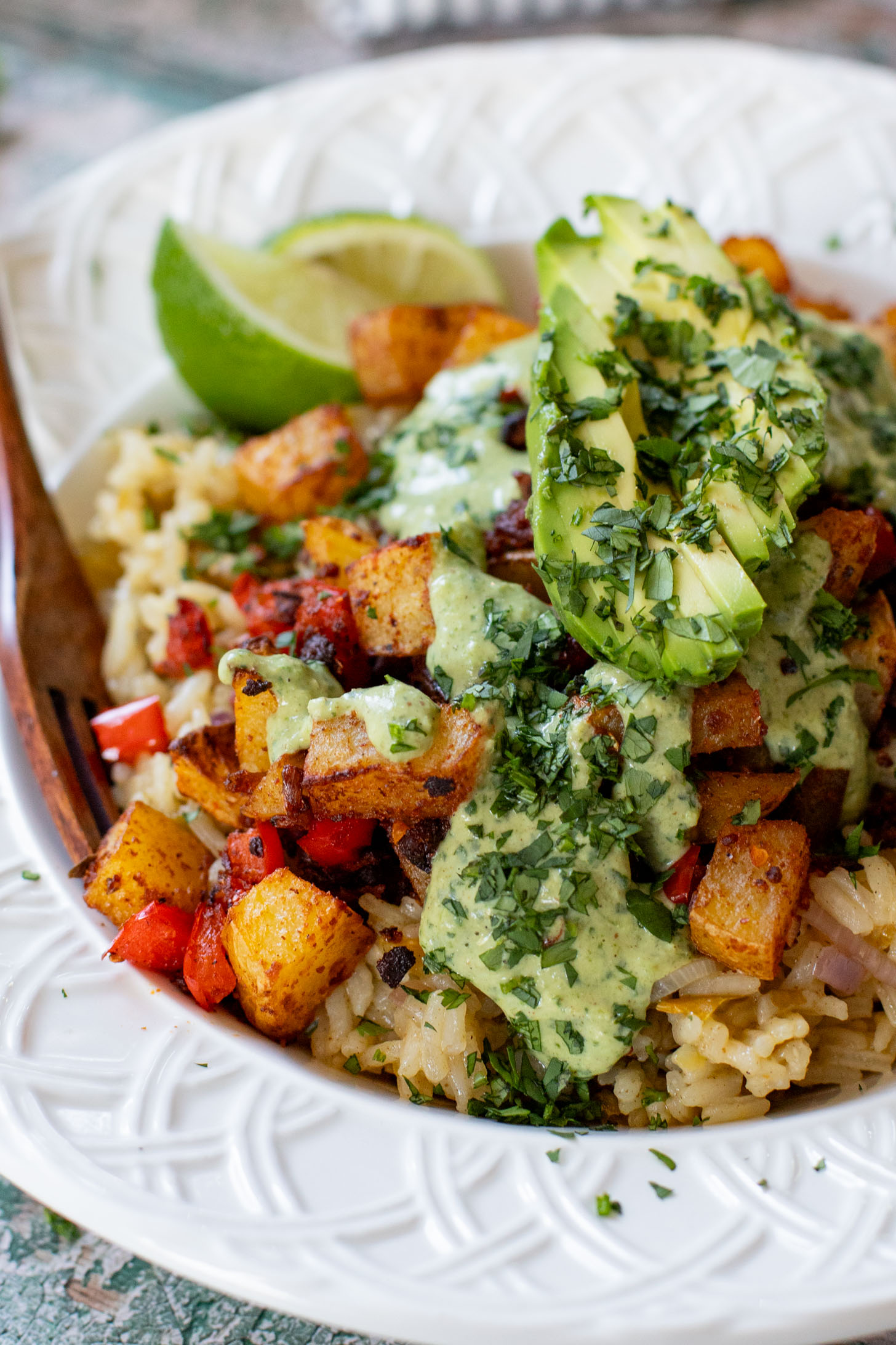 These Crispy Potato & Green Chile Rice Bowls are filled with flavor-packed rice, crispy potatoes, soy chorizo & a cilantro lime sauce | ThisSavoryVegan.com