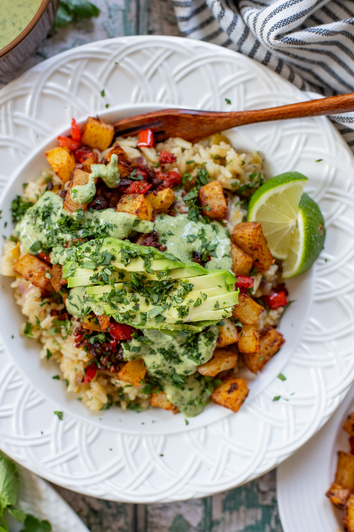 These Crispy Potato & Green Chile Rice Bowls are filled with flavor-packed rice, crispy potatoes, soy chorizo & a cilantro lime sauce | ThisSavoryVegan.com