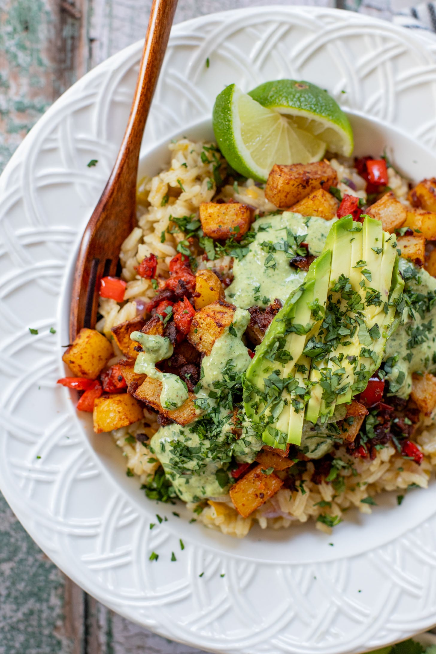 These Crispy Potato & Green Chile Rice Bowls are filled with flavor-packed rice, crispy potatoes, soy chorizo & a cilantro lime sauce | ThisSavoryVegan.com