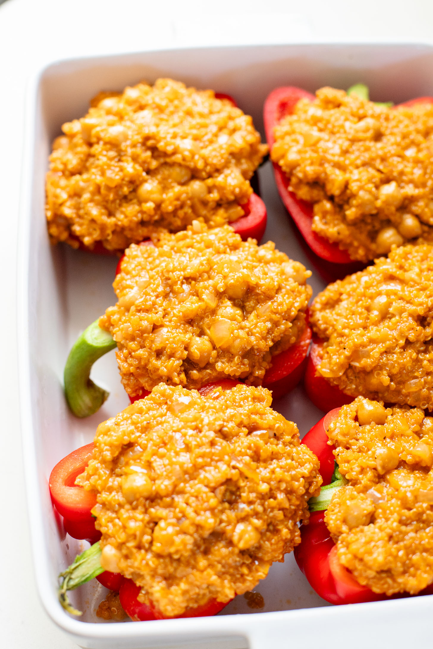 These Red Curry Quinoa Stuffed Peppers are Thai-inspired with quinoa & chickpeas cooked in a coconut red curry sauce & baked in bell peppers | ThisSavoryVegan.com