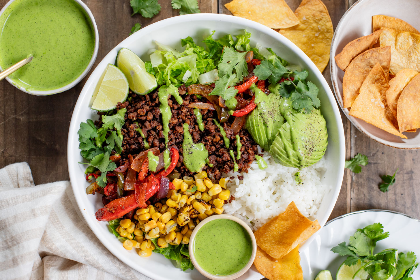 A quick & easy vegan dinner idea, these Sheet Pan Burrito Bowls are filled with vegan "beef" crumbles, fajita veggies & a cilantro yogurt sauce | ThisSavoryVegan.com