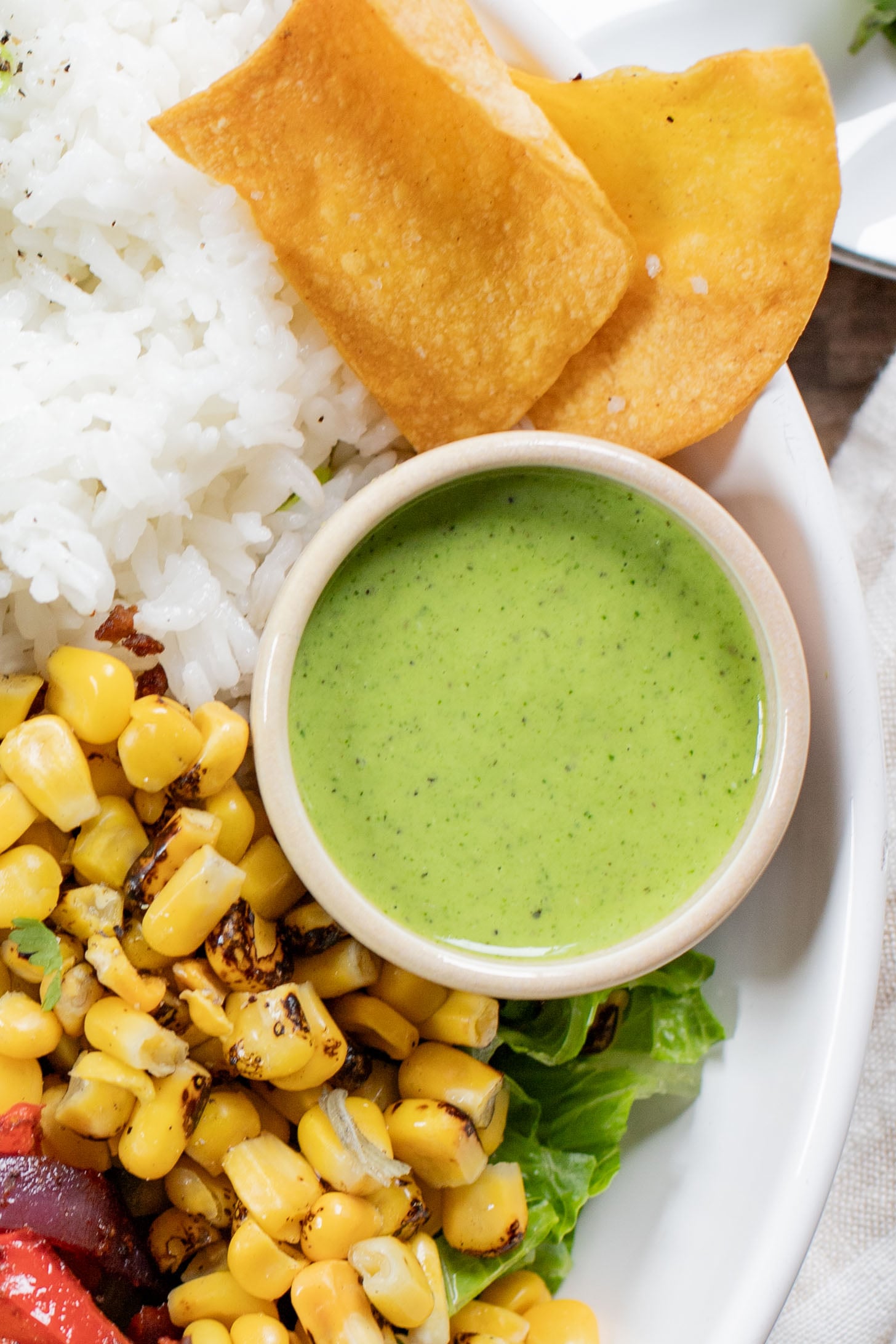 A quick & easy vegan dinner idea, these Sheet Pan Burrito Bowls are filled with vegan "beef" crumbles, fajita veggies & a cilantro yogurt sauce | ThisSavoryVegan.com