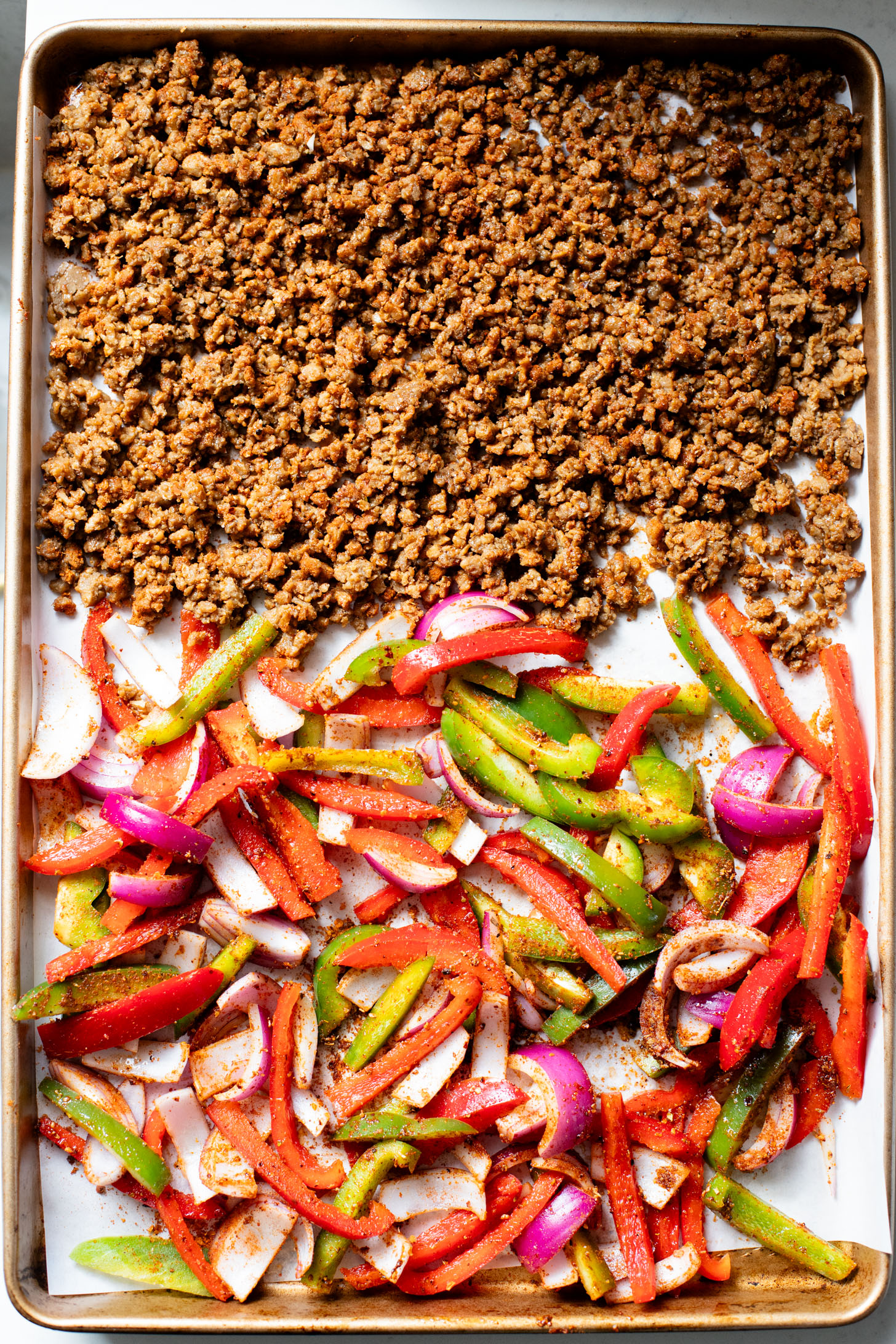 A quick & easy vegan dinner idea, these Sheet Pan Burrito Bowls are filled with vegan "beef" crumbles, fajita veggies & a cilantro yogurt sauce | ThisSavoryVegan.com