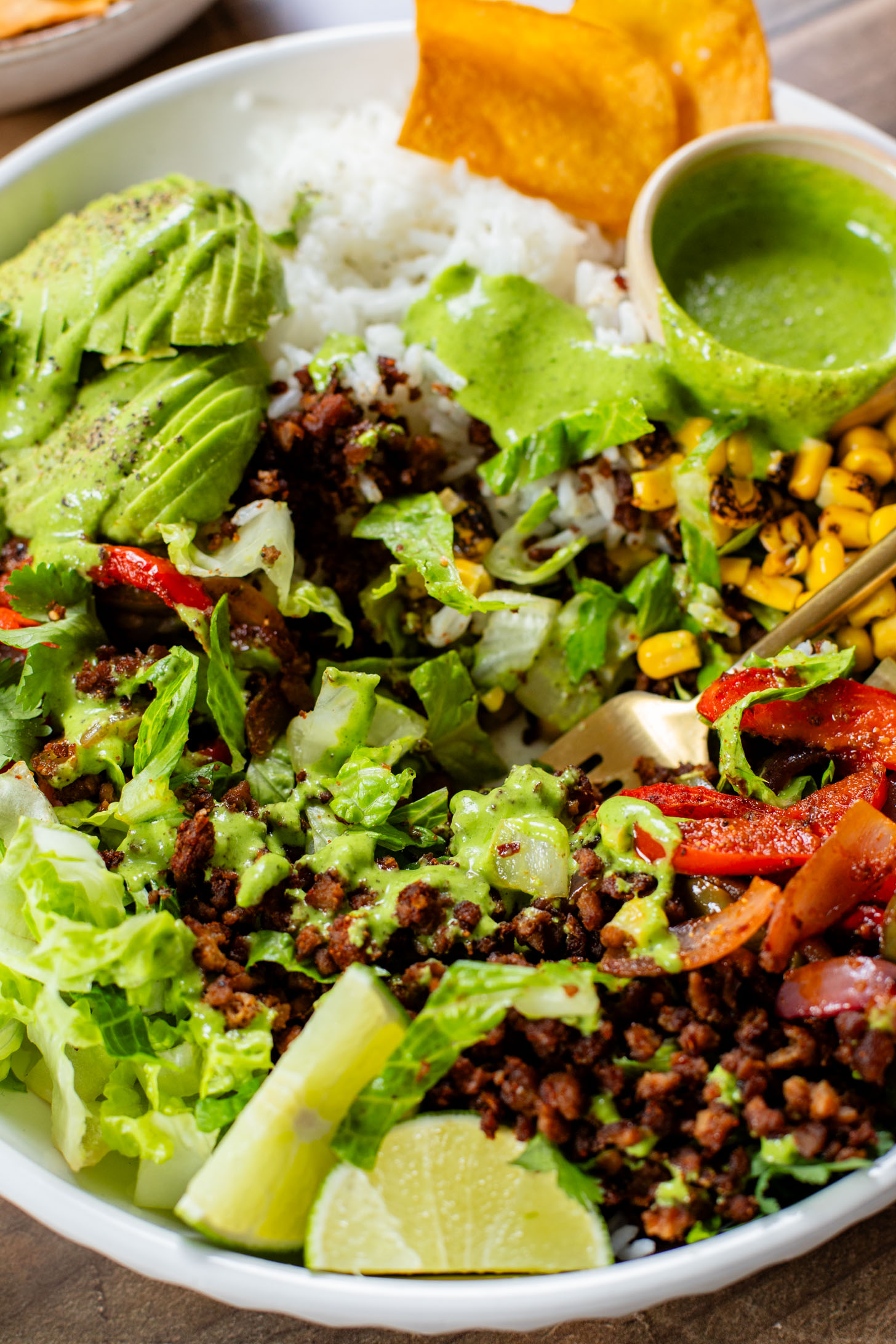 A quick & easy vegan dinner idea, these Sheet Pan Burrito Bowls are filled with vegan "beef" crumbles, fajita veggies & a cilantro yogurt sauce | ThisSavoryVegan.com