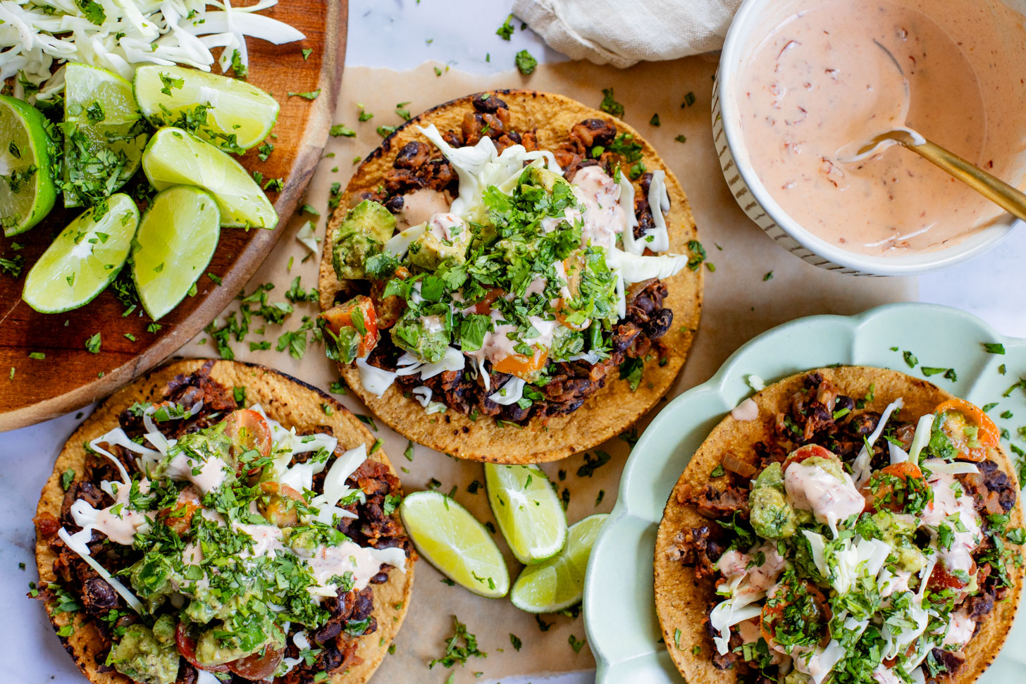 Quick & easy, these Simple Black Bean Tostadas are 100% vegan! Topped with a chunky avocado salsa and chipotle mayo | ThisSavoryVegan.com