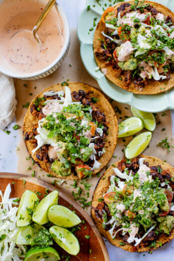 Quick & easy, these Simple Black Bean Tostadas are 100% vegan! Topped with a chunky avocado salsa and chipotle mayo | ThisSavoryVegan.com