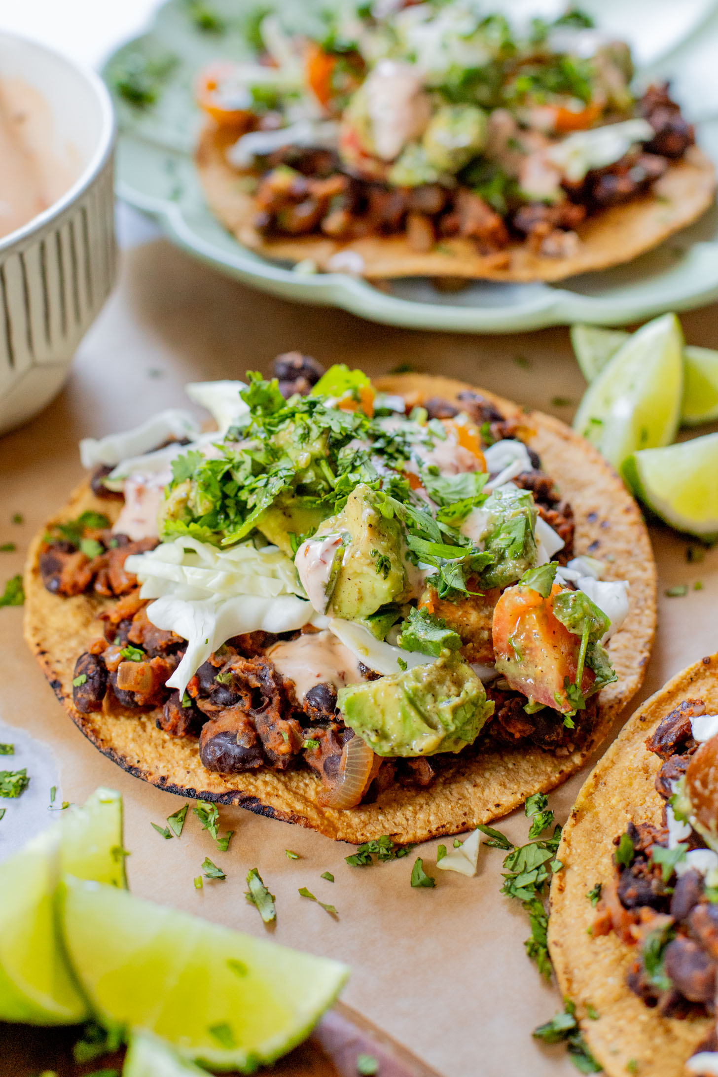 Quick & easy, these Simple Black Bean Tostadas are 100% vegan! Topped with a chunky avocado salsa and chipotle mayo | ThisSavoryVegan.com