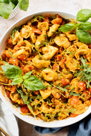 This Pesto Tortellini Pasta Salad is made with a vegan red pepper pesto, tomatoes & arugula. A great vegan side dish for a BBQ | ThisSavoryVegan.com