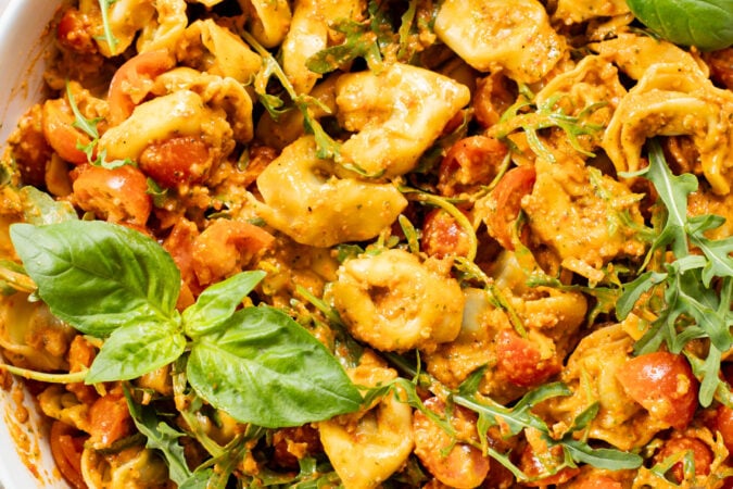 This Pesto Tortellini Pasta Salad is made with a vegan red pepper pesto, tomatoes & arugula. A great vegan side dish for a BBQ | ThisSavoryVegan.com