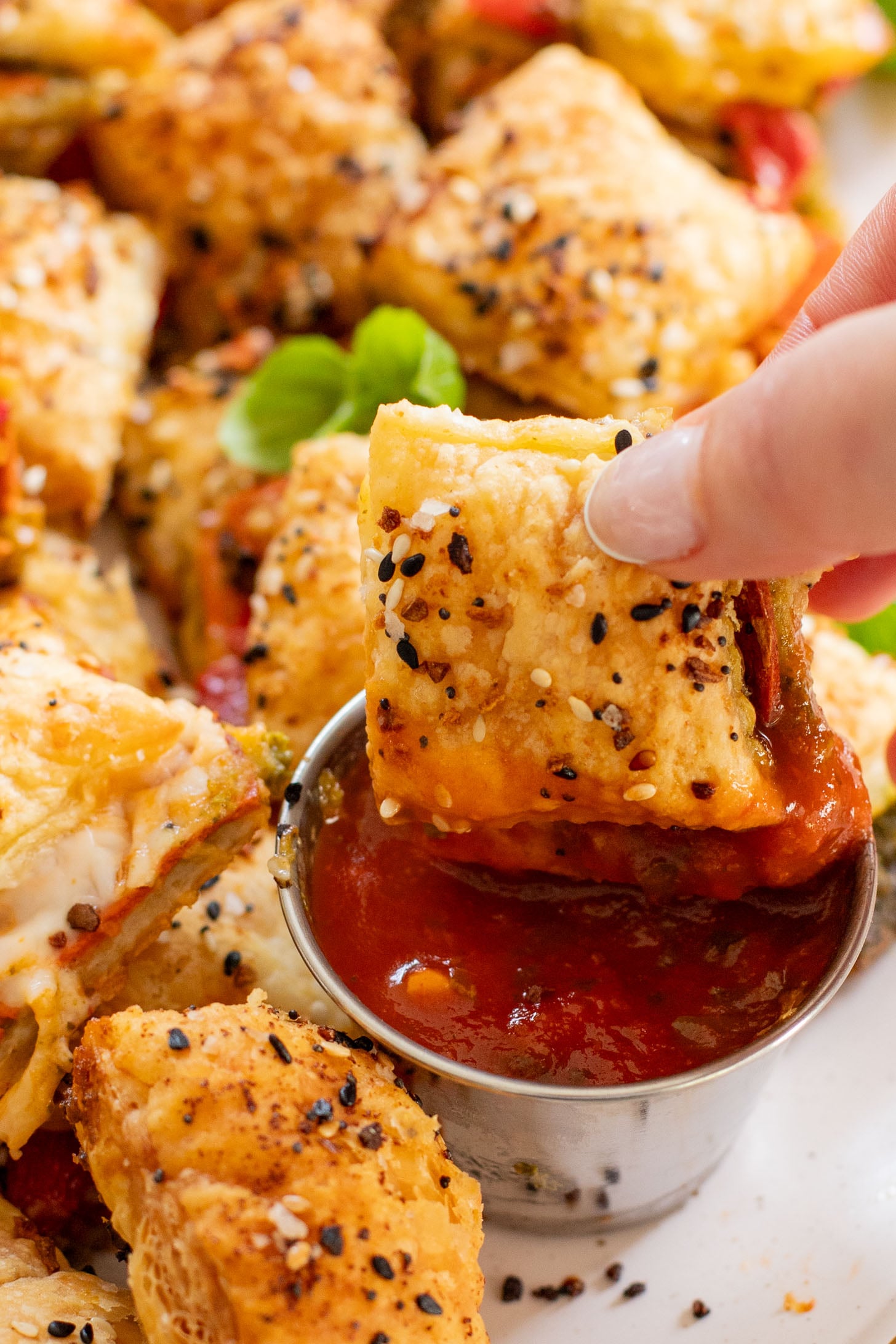 These Puff Pastry Pesto Pizza Bites are the best vegan appetizer. Layers of pizza toppings on puff pastry that is baked until golden | ThisSavoryVegan.com