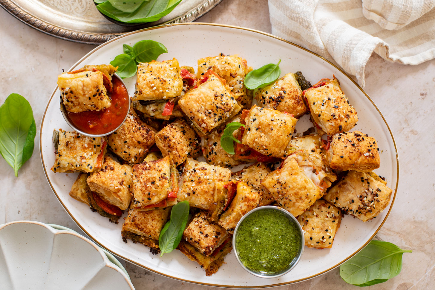 These Puff Pastry Pesto Pizza Bites are the best vegan appetizer. Layers of pizza toppings on puff pastry that is baked until golden | ThisSavoryVegan.com