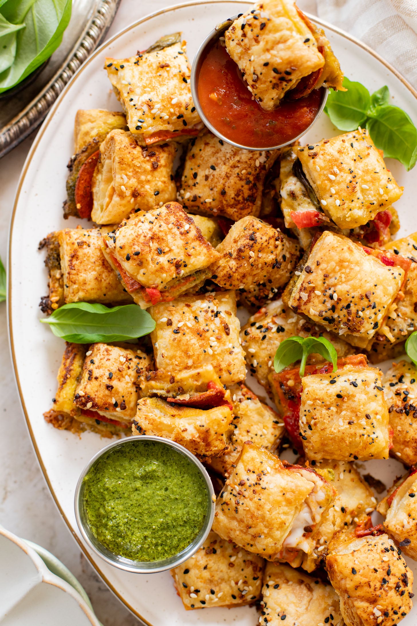 These Puff Pastry Pesto Pizza Bites are the best vegan appetizer. Layers of pizza toppings on puff pastry that is baked until golden | ThisSavoryVegan.com