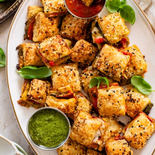These Puff Pastry Pesto Pizza Bites are the best vegan appetizer. Layers of pizza toppings on puff pastry that is baked until golden | ThisSavoryVegan.com