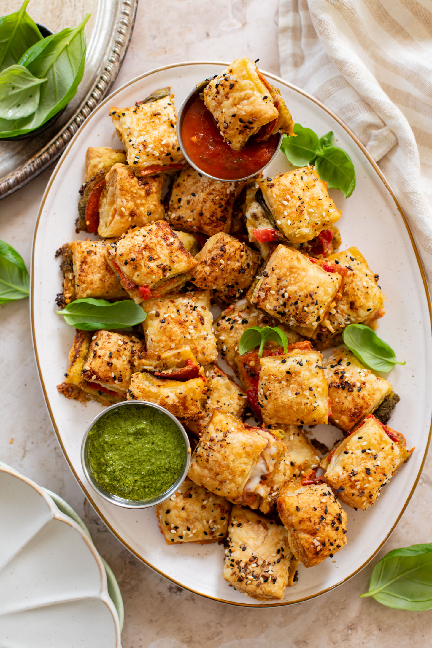 These Puff Pastry Pesto Pizza Bites are the best vegan appetizer. Layers of pizza toppings on puff pastry that is baked until golden | ThisSavoryVegan.com