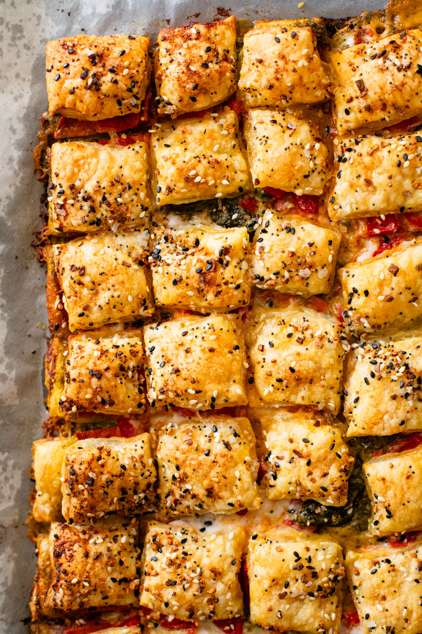 These Puff Pastry Pesto Pizza Bites are the best vegan appetizer. Layers of pizza toppings on puff pastry that is baked until golden | ThisSavoryVegan.com